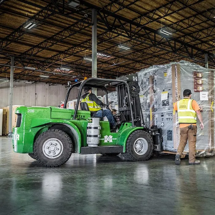 Omega Morgan millwright crew positioning equipment with a forklift